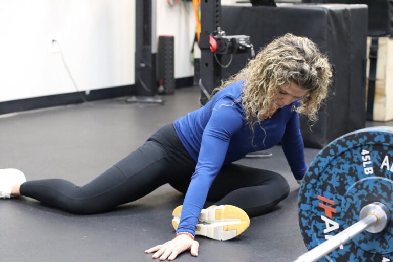 Woman performing Kinstretch mobility training exercise at Omni Wellness & Performance gym in Fairfax, Virginia